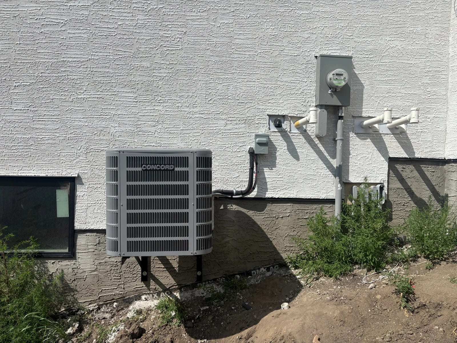 AC installation Calgary: a new Concord air conditioner mounted on a wall bracket beside a Calgary home