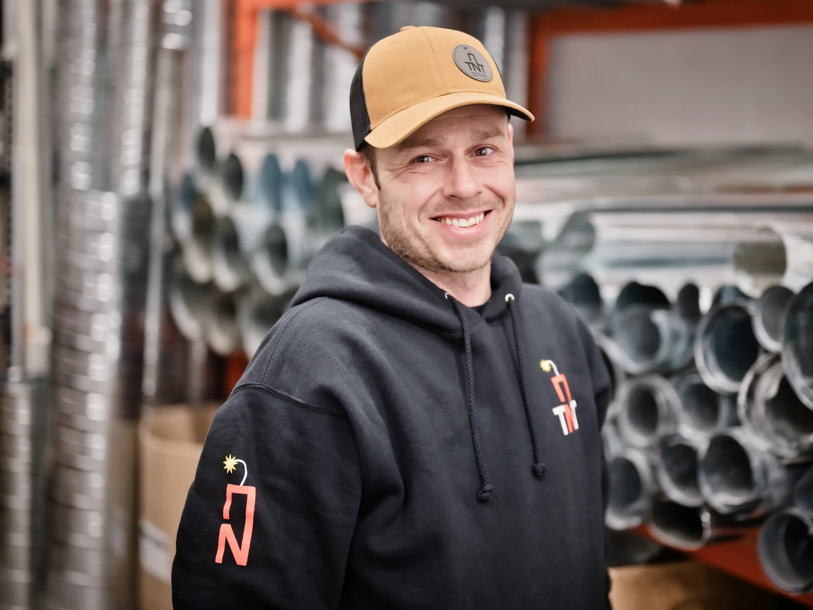Furnace repair Calgary: one of the TNT owners in the Calgary shop, among rolls of galvanised duct pipe