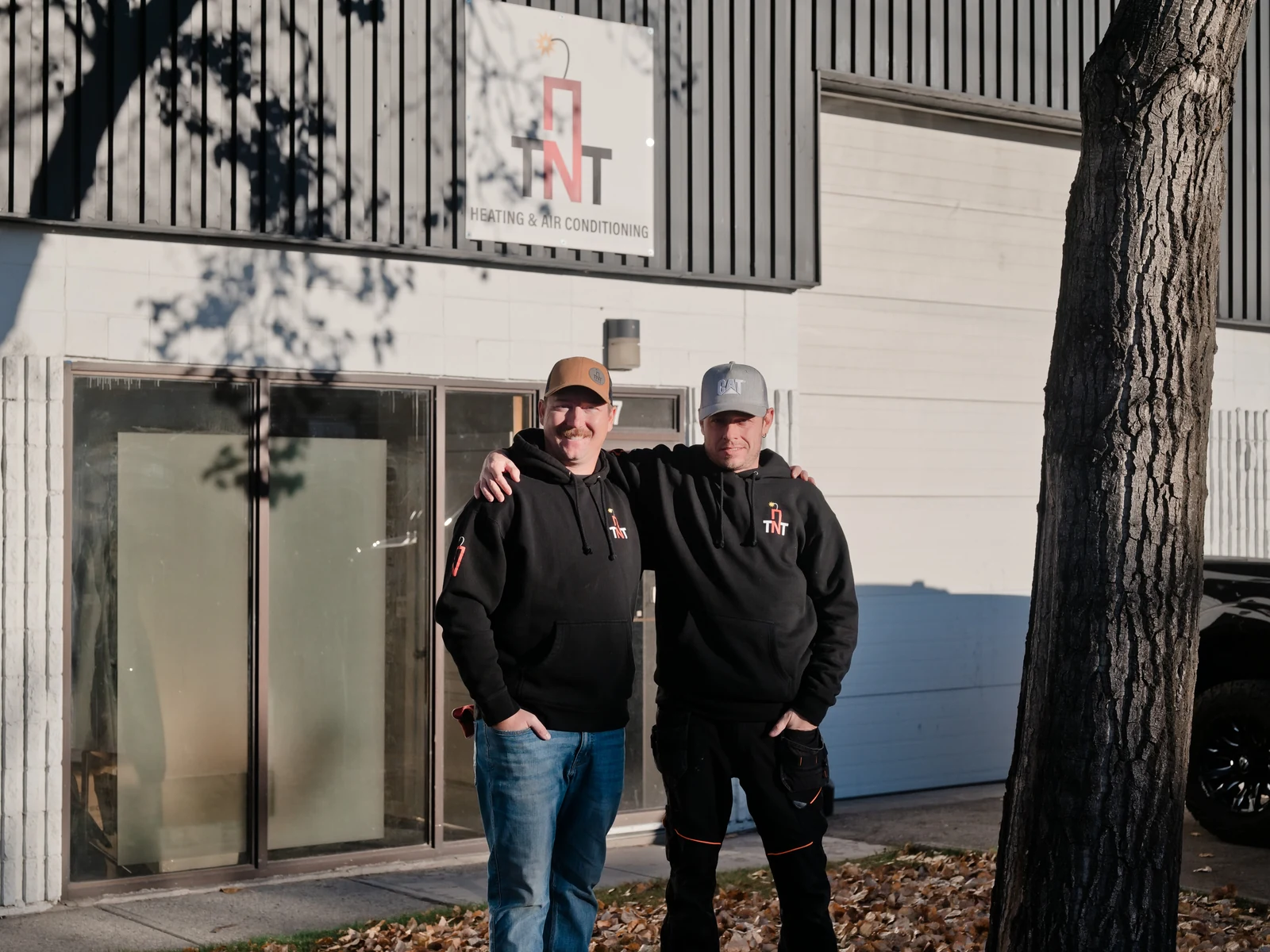 Hot water tank replacement Calgary: the two TNT owners outside the TNT Heating & Air Conditioning shop in southeast Calgary