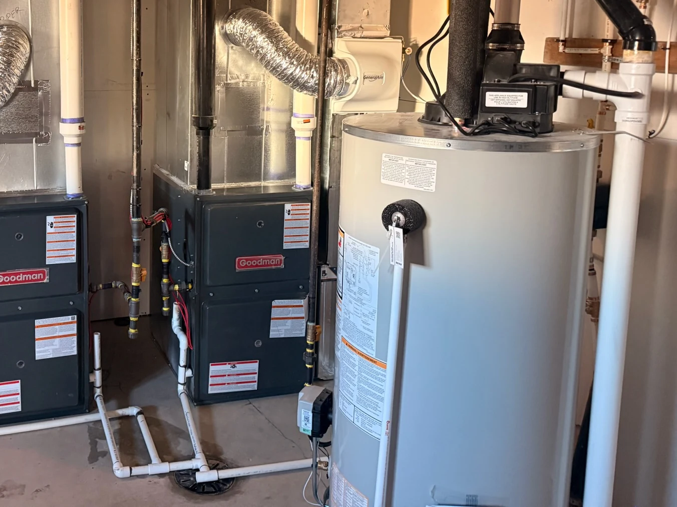 Hot water tank replacement Calgary: a gas hot water tank installed by TNT beside the furnaces in a Calgary basement