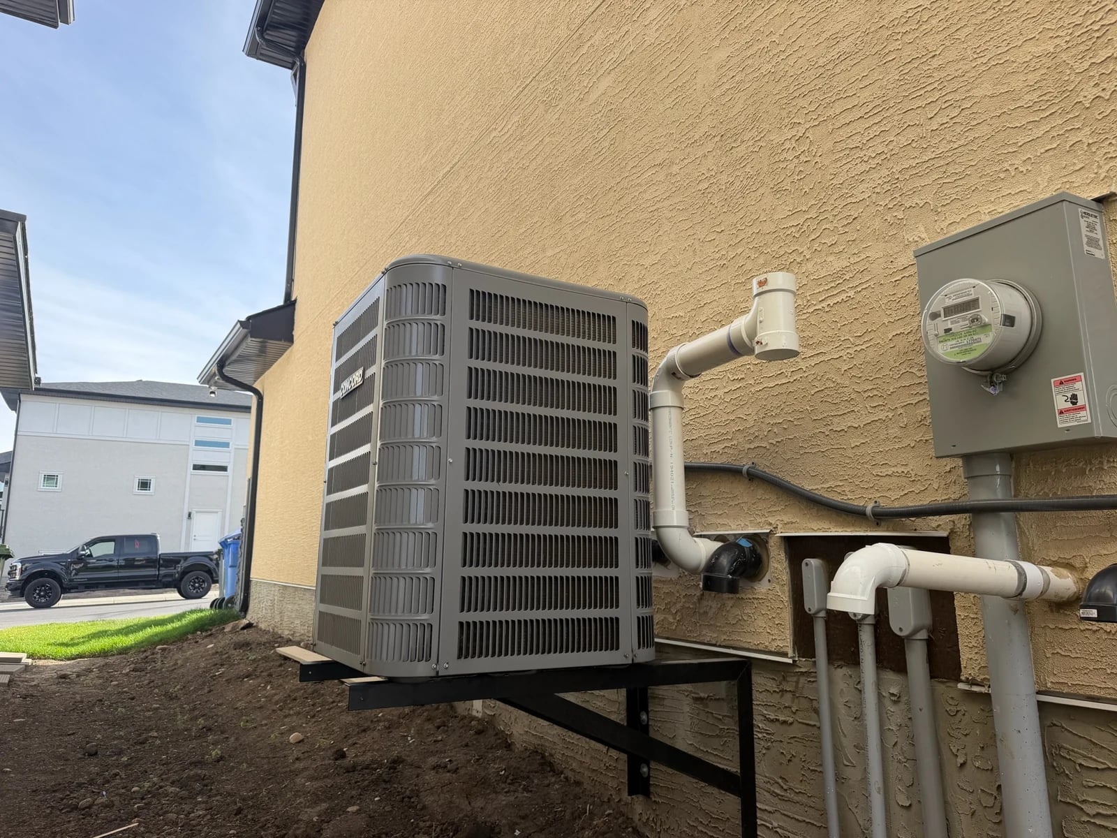 HVAC financing Calgary: a new Concord air conditioner mounted on a wall bracket beside a Calgary home